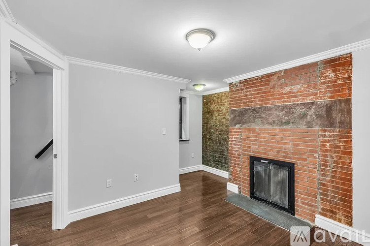 A room with a fireplace and a brick wall.