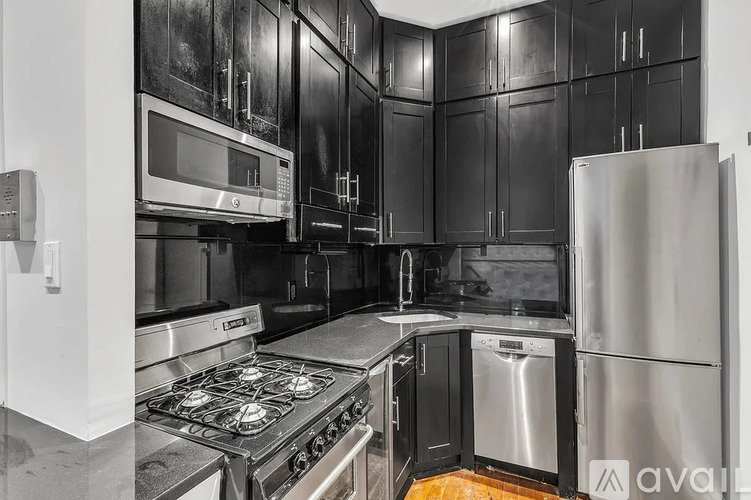 A kitchen with black cabinets and stainless steel appliances.