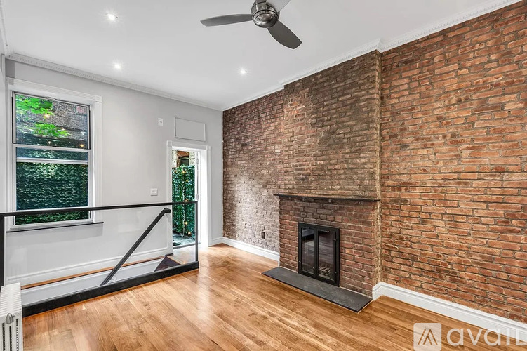 A room with a brick wall and a fireplace.