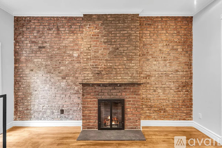 A fireplace with a brick wall behind it.