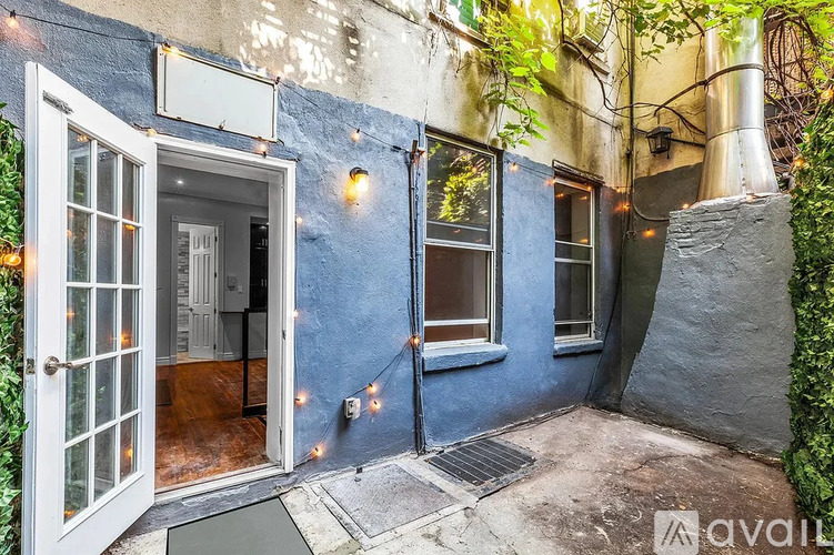 A small, cozy patio area with a doorway leading to a room.
