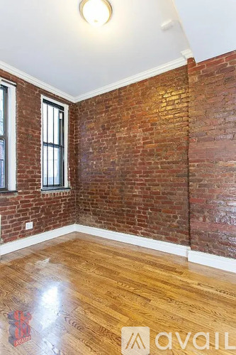 A room with wooden floors and a brick wall.