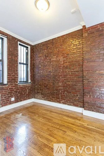A room with wooden floors and a brick wall.