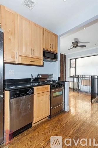 A kitchen with wooden cabinets and black appliances.