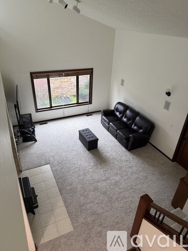 A living room with a black leather couch and a television.