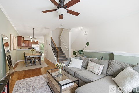 A living room with a grey couch and a wooden coffee table.