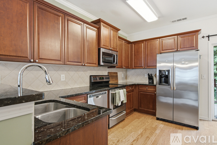 A kitchen with wooden cabinets and a black counter top.