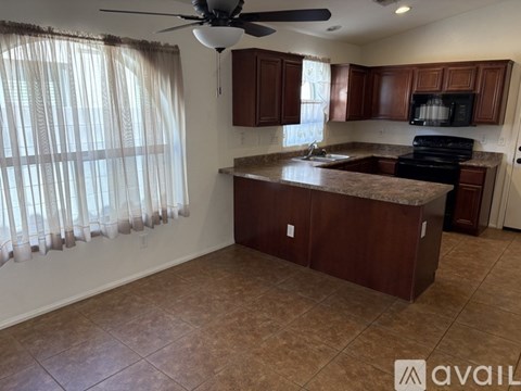 A kitchen with brown cabinets and a black stove top oven.