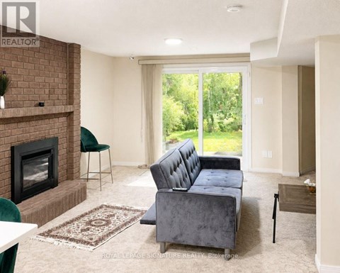 A living room with a grey couch and a fireplace.