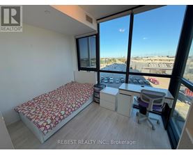 A bedroom with a large bed and a desk with a chair.