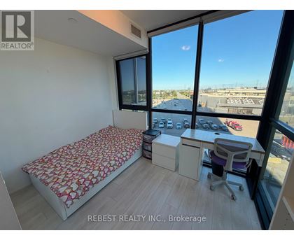 A bedroom with a large bed and a desk with a chair.