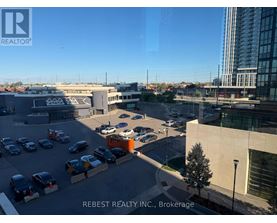 A parking lot with cars and a building in the background.