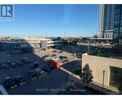A parking lot with cars and a building in the background.