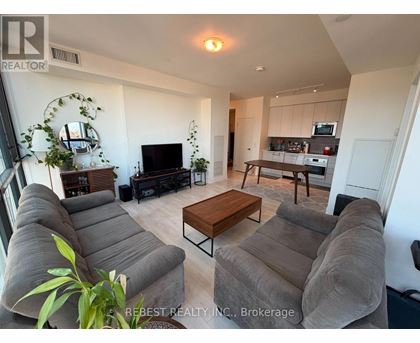 A living room with a grey couch and a wooden coffee table.