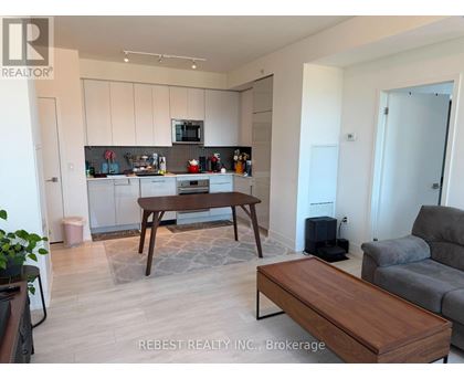 A modern kitchen with white cabinets and a wooden island.