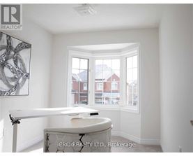 A room with a table and a window overlooking a red building.
