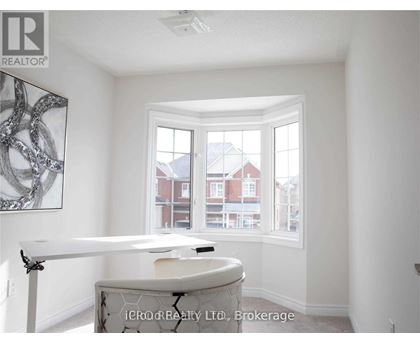 A room with a table and a window overlooking a red building.