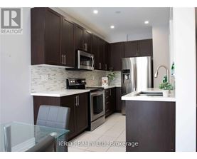 A modern kitchen with dark brown cabinets and stainless steel appliances.