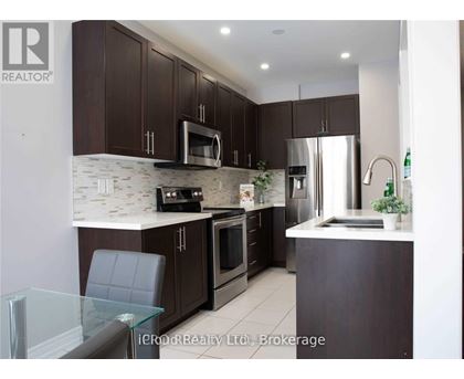 A modern kitchen with dark brown cabinets and stainless steel appliances.