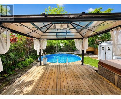 A wooden deck with a pool under a canopy.