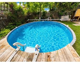 A small blue pool with a wooden deck and steps.