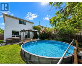 A pool in a backyard with a house in the background.