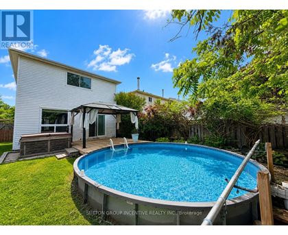 A pool in a backyard with a house in the background.