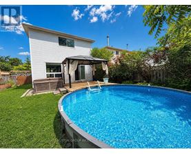 A pool in a backyard with a house in the background.