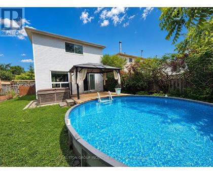 A pool in a backyard with a house in the background.