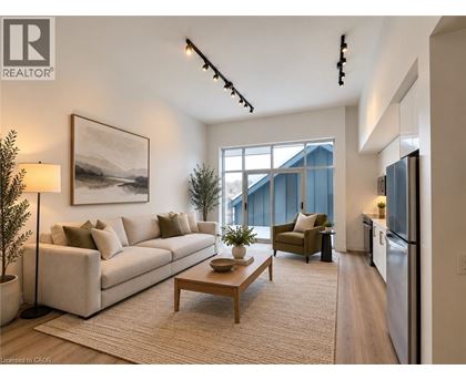 A well-lit living room with a large window, a couch, a coffee table, and a painting on the wall.