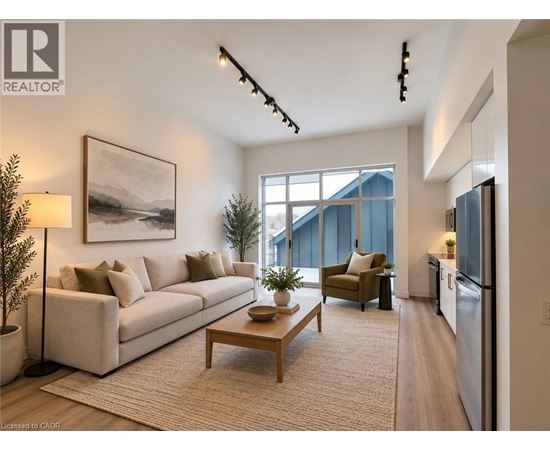 A well-lit living room with a large window, a couch, a coffee table, and a painting on the wall.