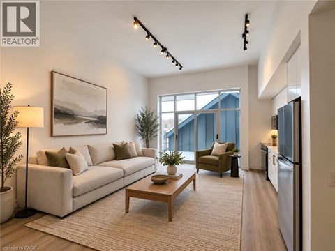 A well-lit living room with a large window, a couch, a coffee table, and a painting on the wall.
