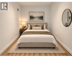 A bedroom with a large bed and a painting on the wall.