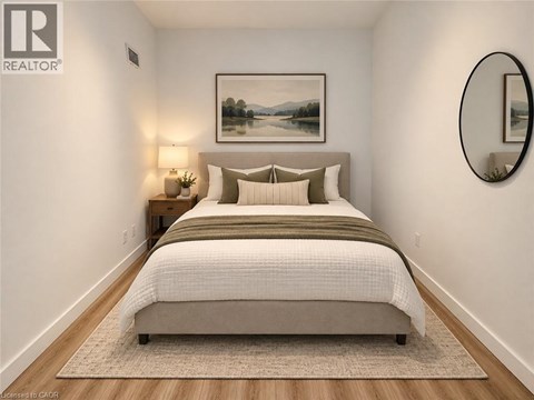 A bedroom with a large bed and a painting on the wall.