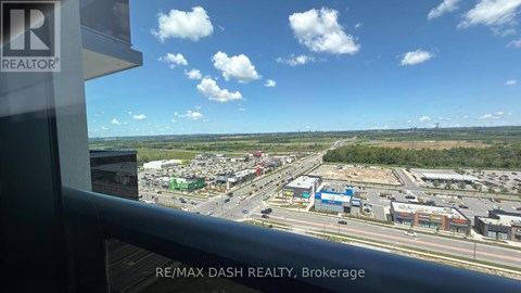 A view from a window of a busy street with a sign that says RE/MAX DASH REALTY, Brokerage.