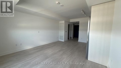 A room with a white wall and a wooden floor.