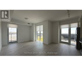 A spacious room with a view of the city through large windows.