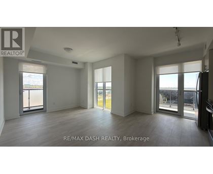 A spacious room with a view of the city through large windows.