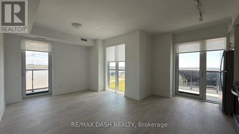 A spacious room with a view of the city through large windows.