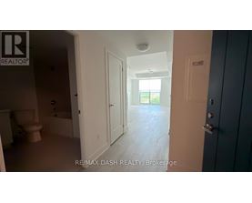 A room with a toilet, sink, and a door leading to a hallway.