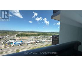 A view from a window of a parking lot and buildings.