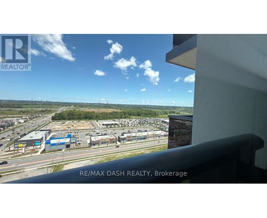 A view from a window of a parking lot and buildings.