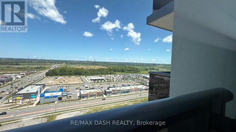 A view from a window of a parking lot and buildings.