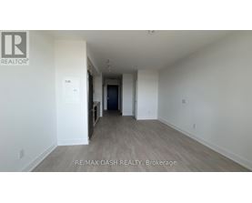 A spacious room with a door at the end of the hallway.