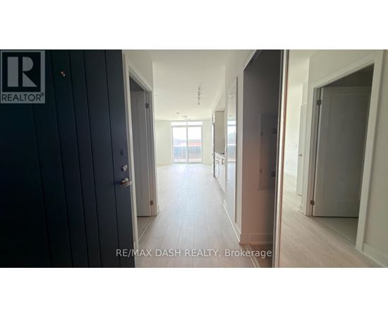 A hallway with a door on the left and a window in the distance.