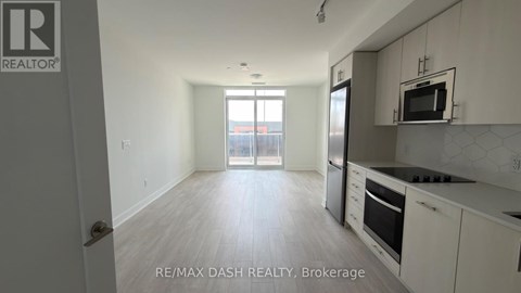 A well-lit kitchen with white cabinets and a microwave above the stove.