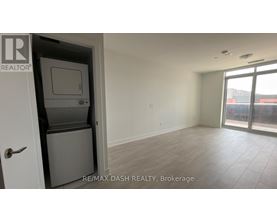 A room with a door and a window with a view of a building outside.