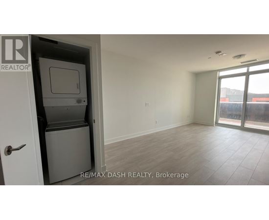 A room with a door and a window with a view of a building outside.