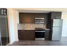 A kitchen with a refrigerator, microwave, and oven.