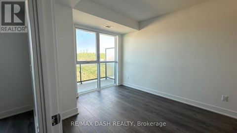 A room with a sliding glass door leading to a balcony.